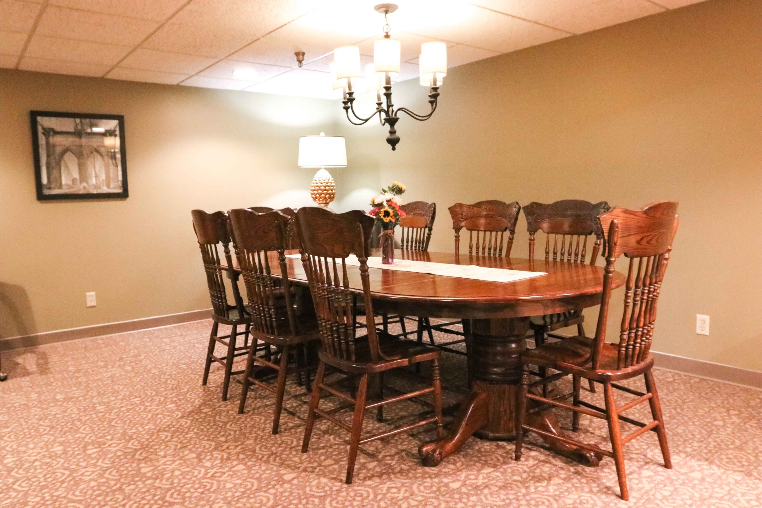 Interior image of the formal dining room with a sturdy wooden table and 8 chairs at Sedgwick Plaza.
