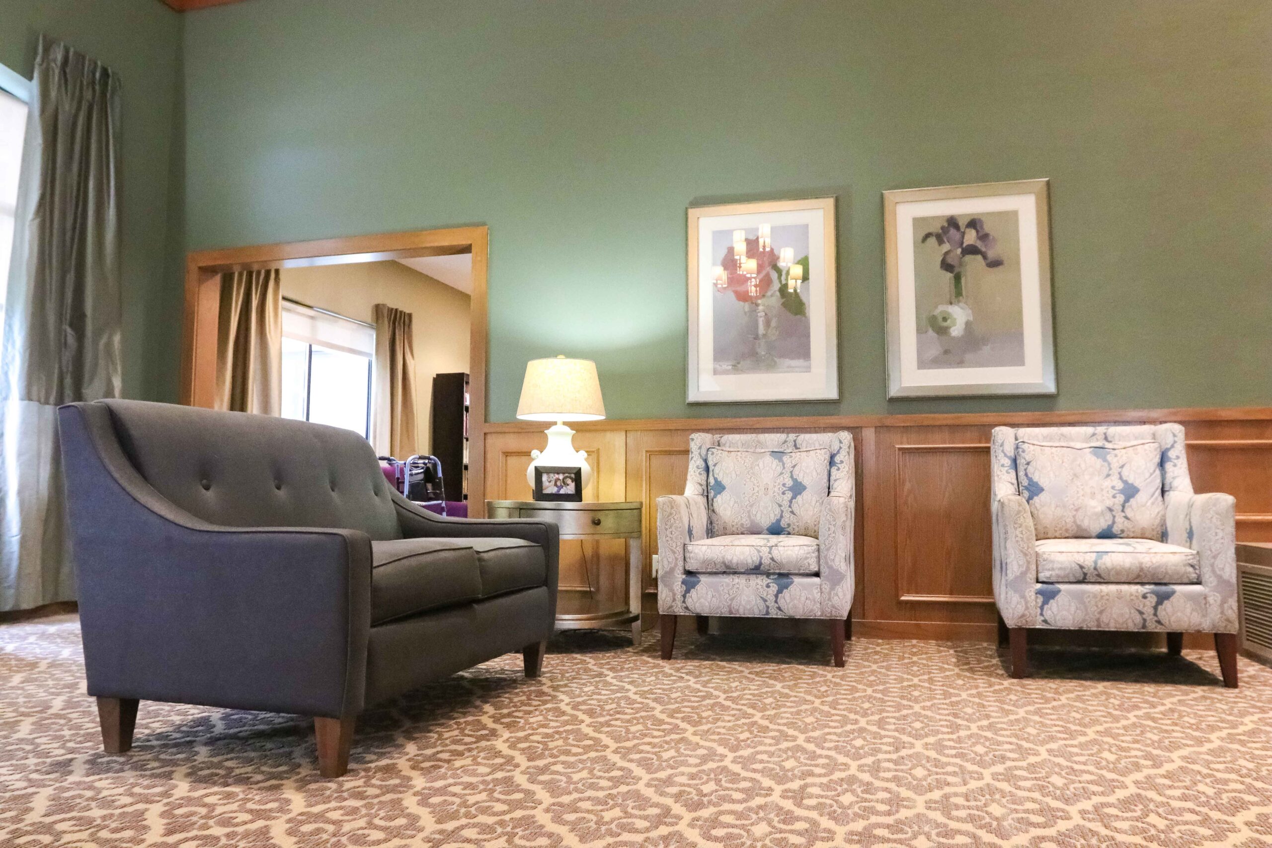 Interior image of a sitting room with artwork, tall ceilings, and comfortable chairs at Sedgwick Plaza.